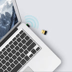 Laptop with USB wireless adapter plugged in, showing Wi-Fi signal icon and a detached USB adapter